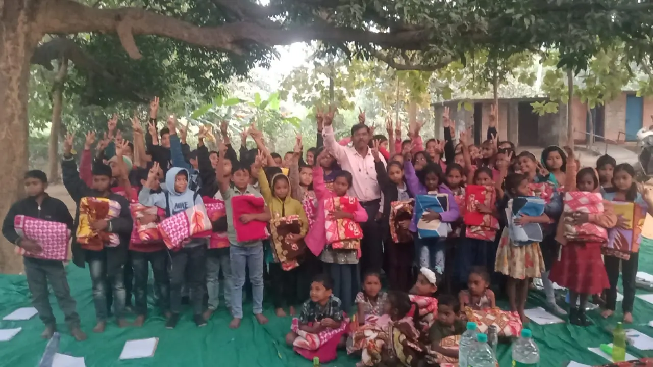 Children posing with their new blankets after a winter distribution drive