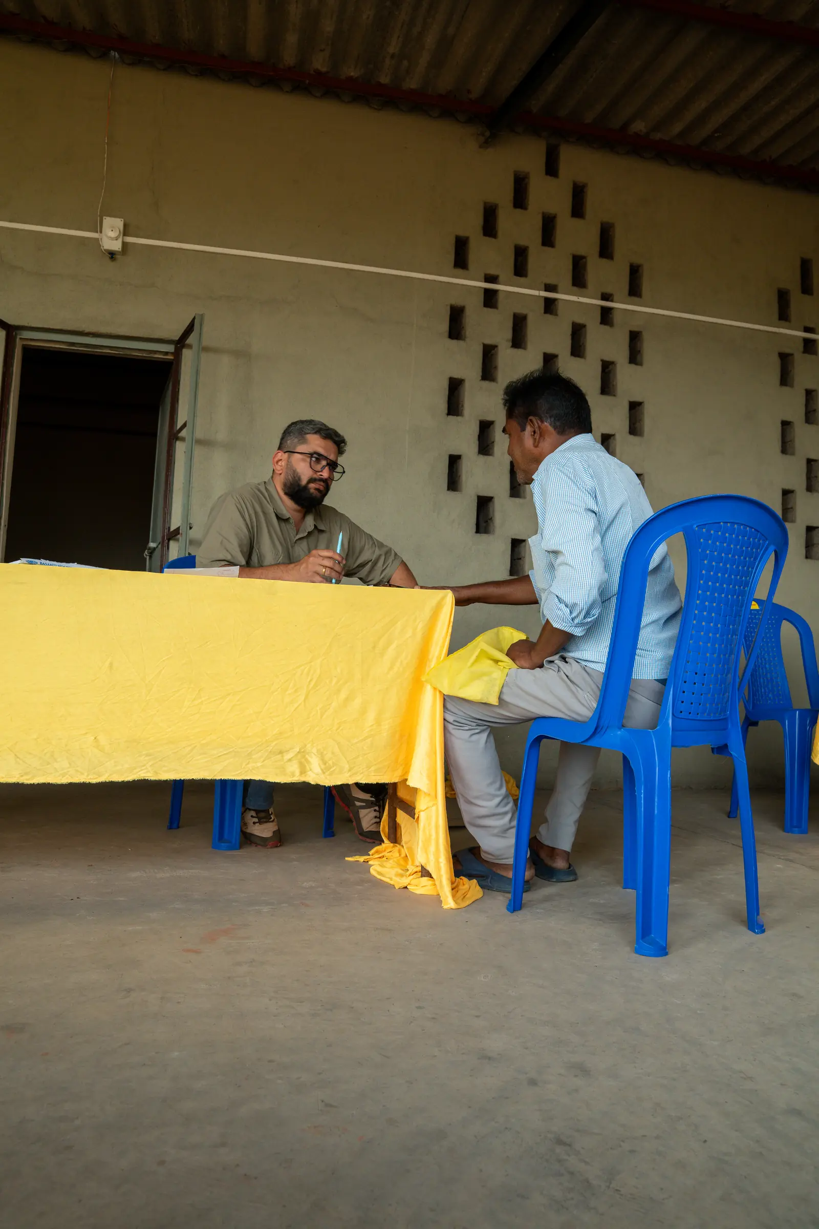 An OAI volunteer registering a patient at a medical camp check-in desk