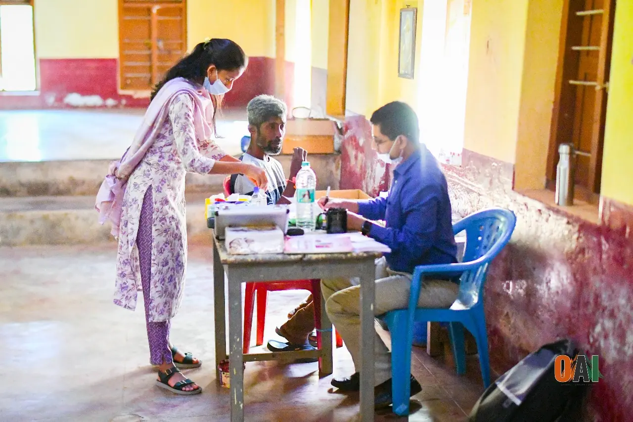 An OAI volunteer recording a patient's diagnosis at a medical camp