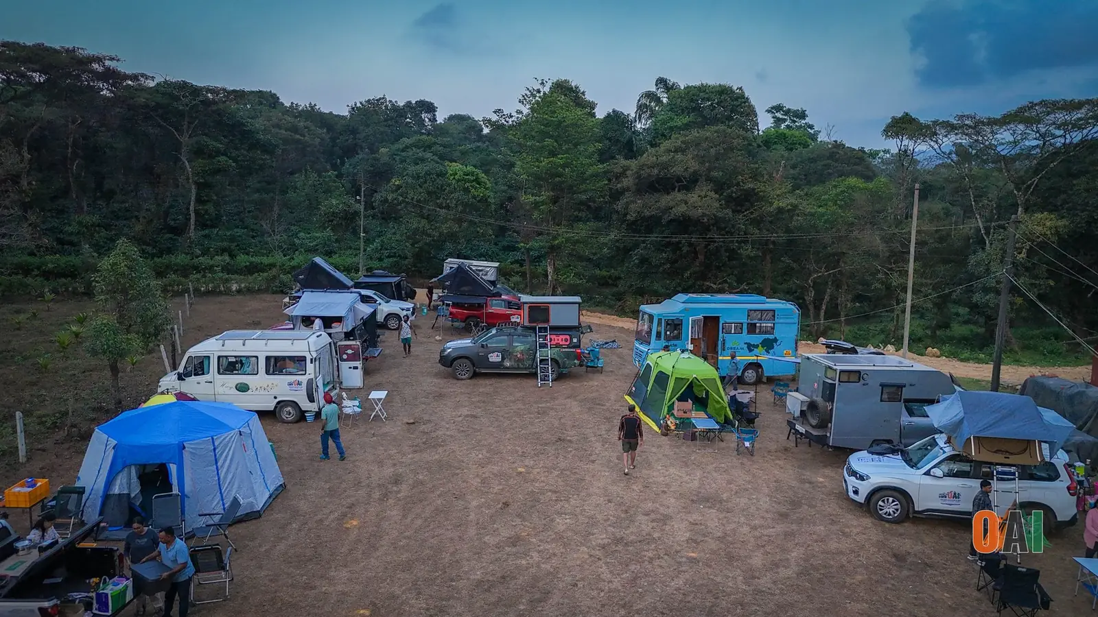 Aerial view of an OAI campsite with tents, campervans and overlander vehicles among the trees