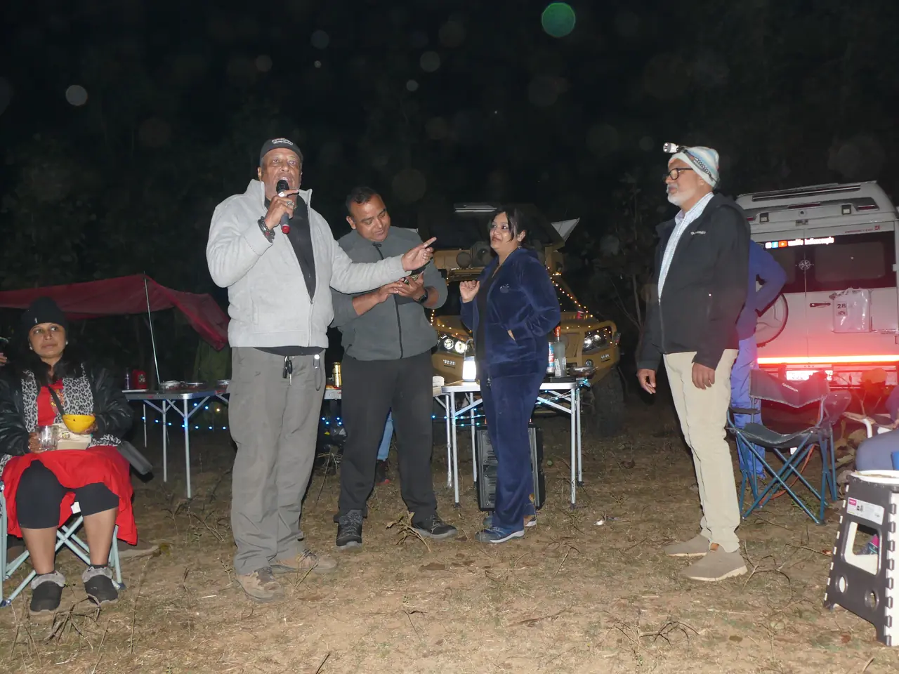 Members sharing stories on the mic at a night camp