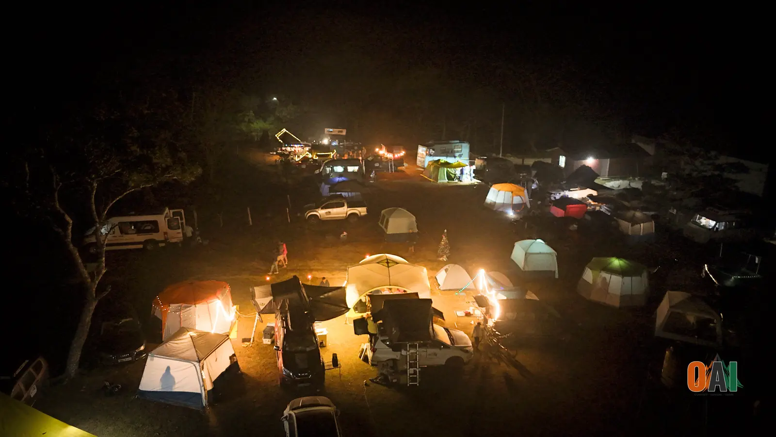 Aerial night view of the illuminated Sangam 2024 campsite in Coorg