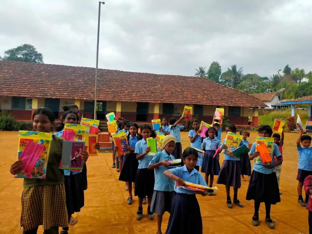 Local schoolchildren with donated stationery kits near Theralu Village