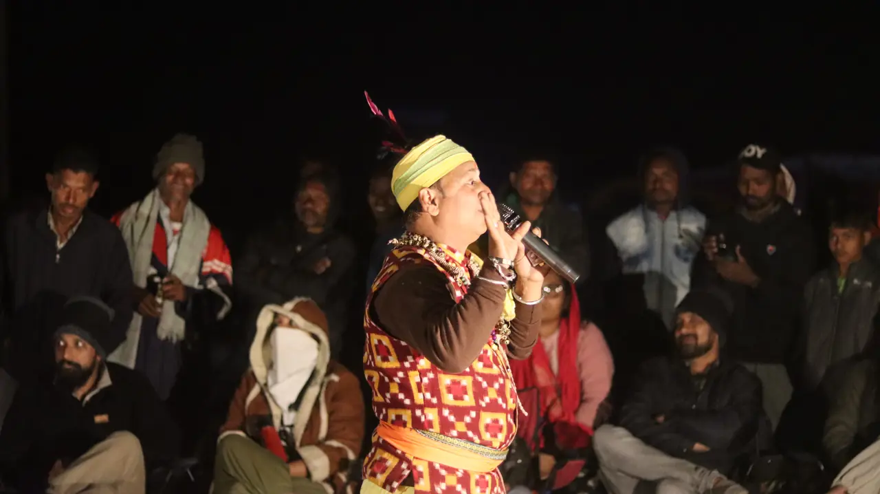A folk performer singing to OAI members at Satkosia