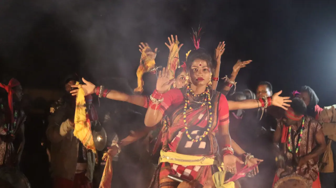 A tribal dancer performing by firelight at Satkosia