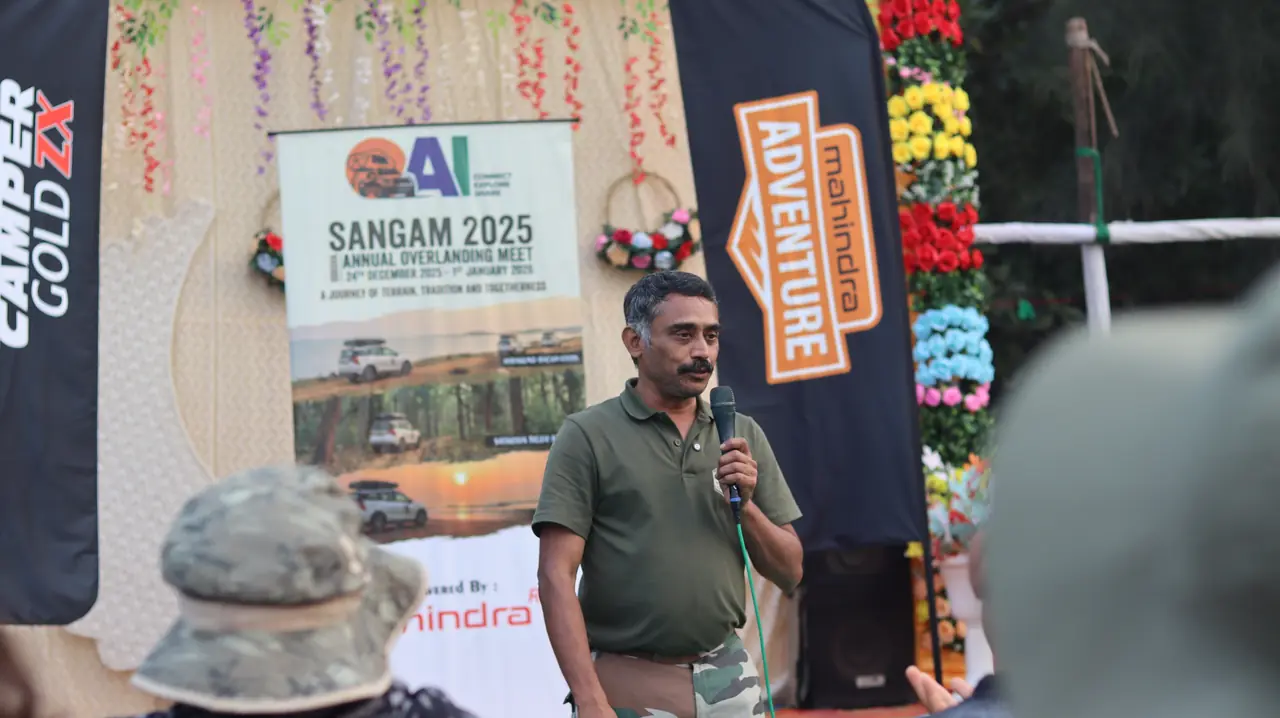A member addressing the group on stage at Puri Beach
